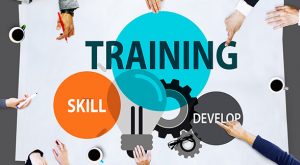 A group of people around a paper with the words training and skill.