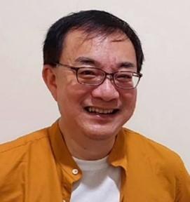 an asian man wearing glasses and a yellow shirt.
