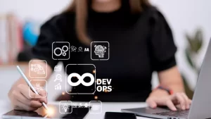 Person working at a desk with a tablet and laptop, surrounded by digital icons related to DevOps.
