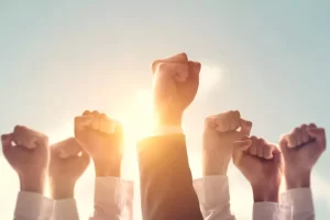Raised fists against a sunset sky, symbolizing unity and strength.