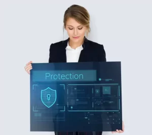 A person in a suit holds a large digital screen displaying security icons and the word "Protection.